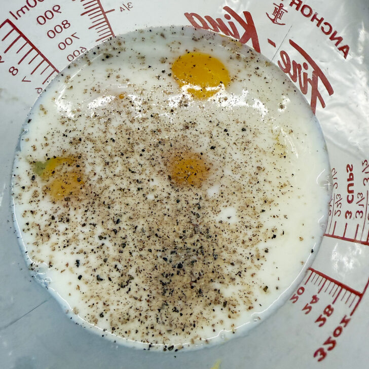 Egg and milk mixture in a large measuring cup.