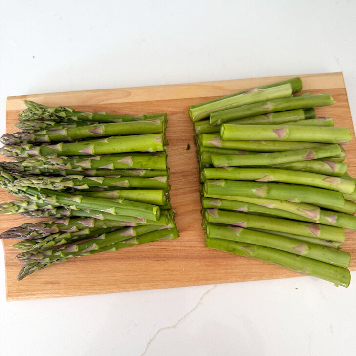 Asparagus spears cut on a cutting board.