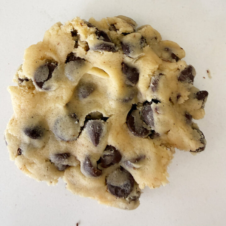 Flattening the cookie dough ball into a disc.