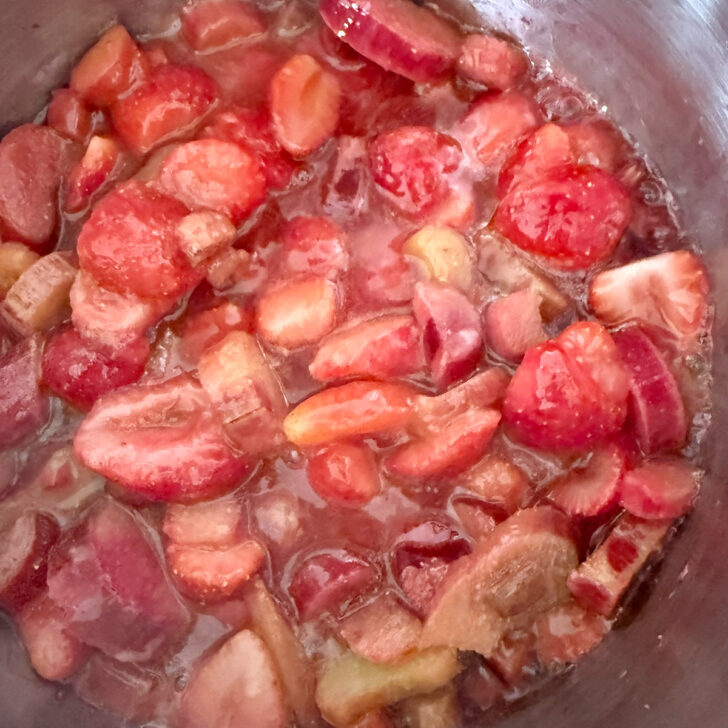 Strawberry rhubarb mixture cooking in a saucepan.