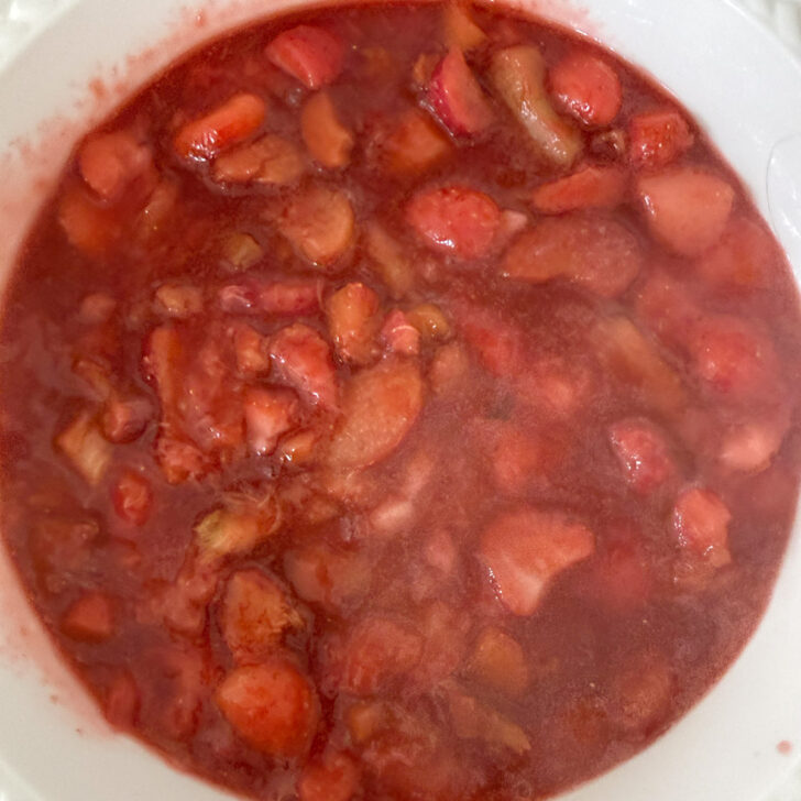 Strawberry rhubarb mixture is added to the bottom of a baking dish.
