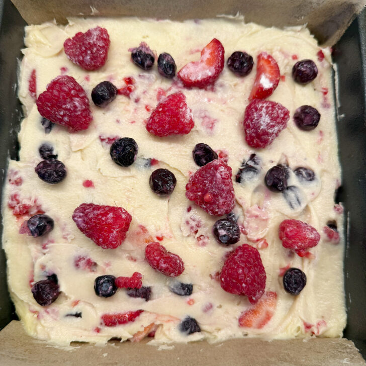 A bit more fruit scattered on top of the cake before baking.