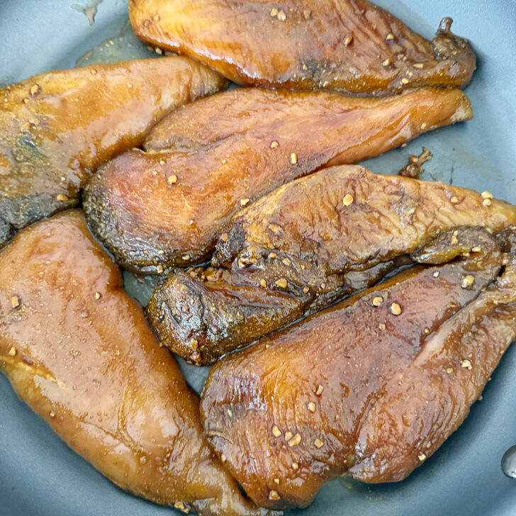 Marinated chicken in a skillet.