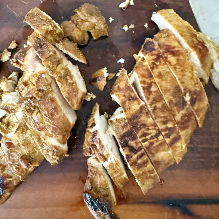 Cooked chicken sliced on a cutting board.