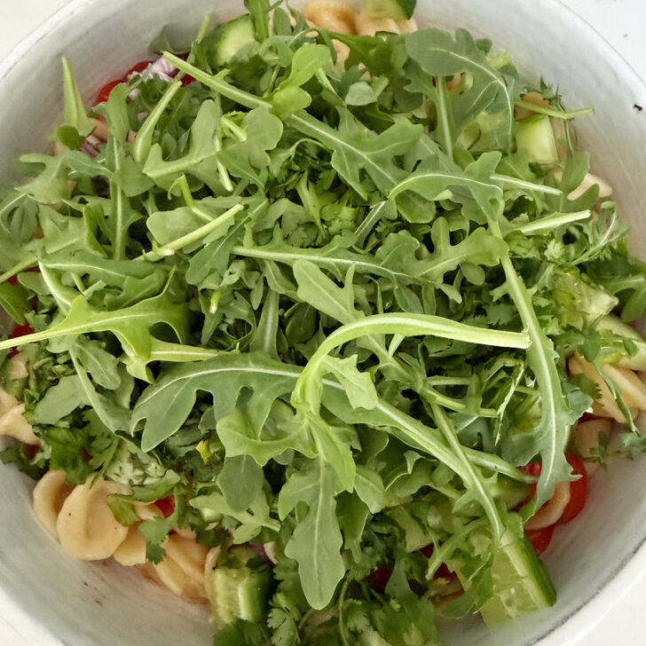 Arugula added to the salad bowl.