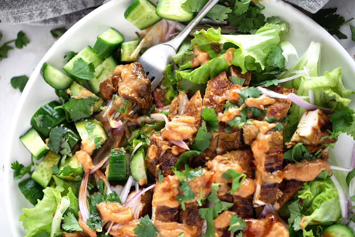 Peanut chicken salad plated with lime wedges.