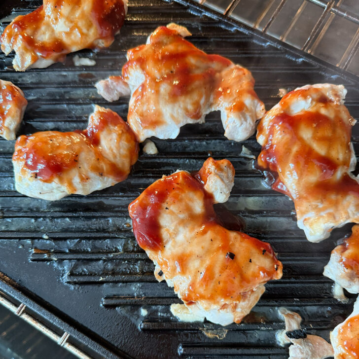 BBQ chicken cooking on a grill pan.