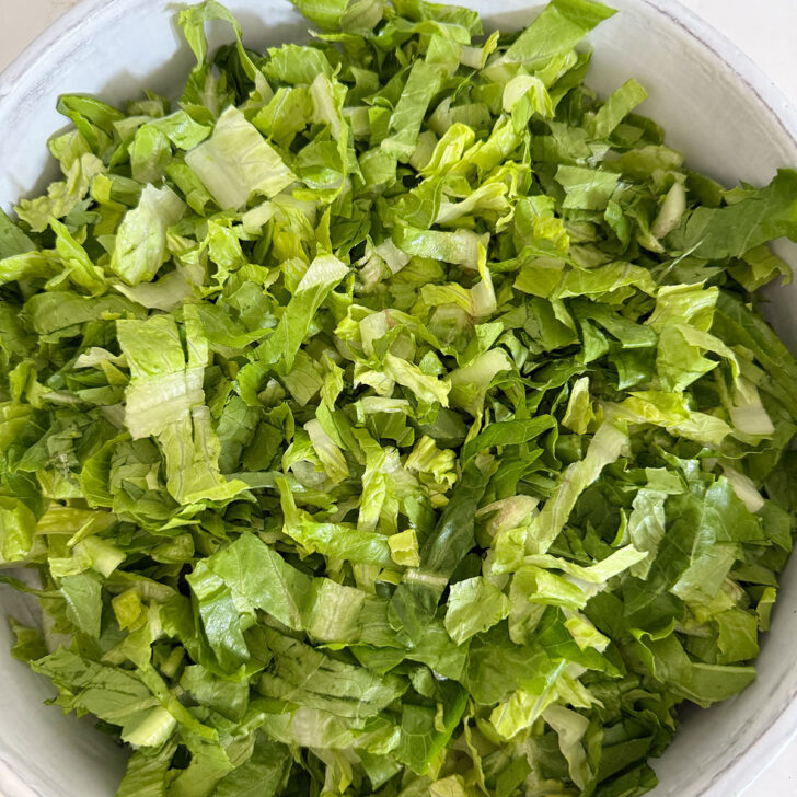 Chopped romaine lettuce added to the salad bowl.