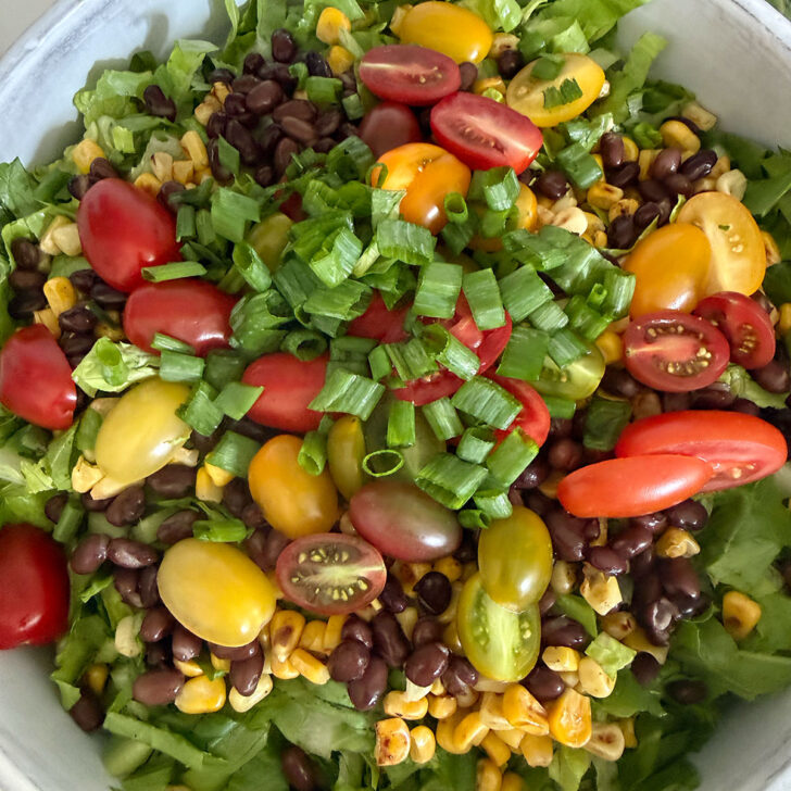 Tomatoes, black beans, corn and green onion added to the salad.