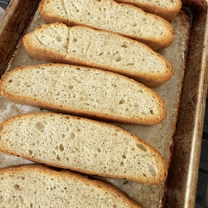 Focaccia slices on a baking sheet after toasting.