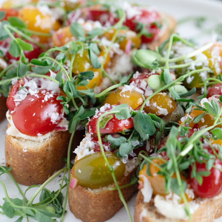 Cherry tomato bruschetta assembled on a plate.