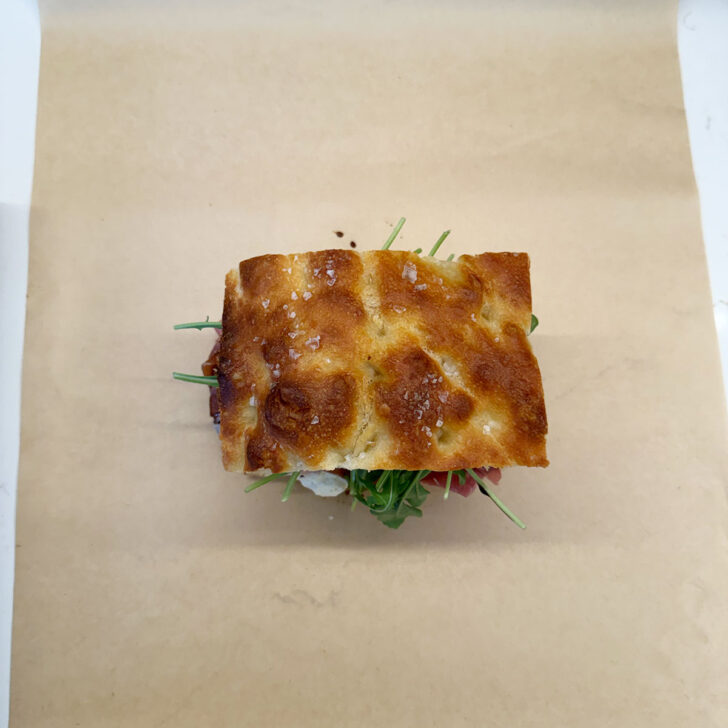Focaccia sandwich placed on top of a sheet of parchment paper.