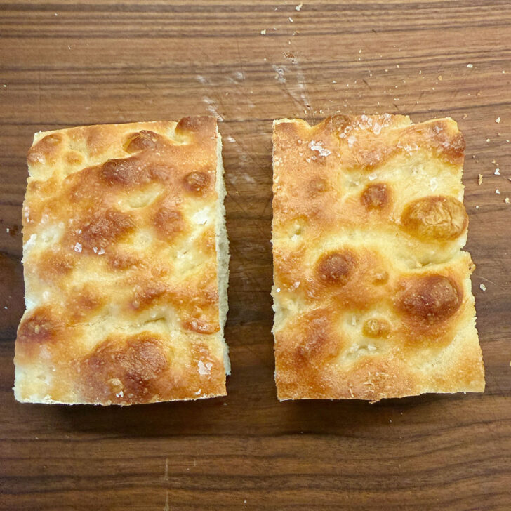 Two pieces of focaccia on a cutting board.