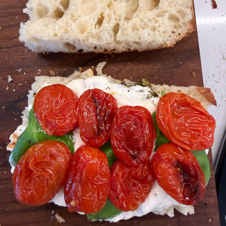 Roasted cherry tomatoes on a focaccia sandwich.