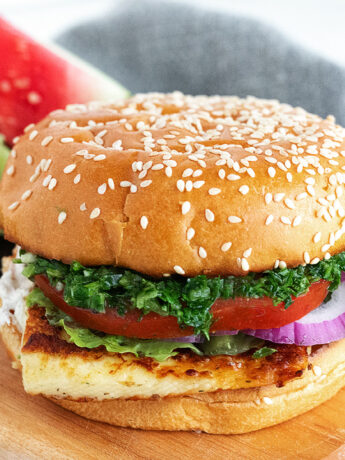 Halloumi burger on a serving board with watermelon.