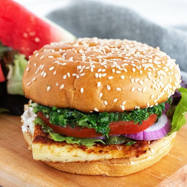 Halloumi burger on a serving board with watermelon.