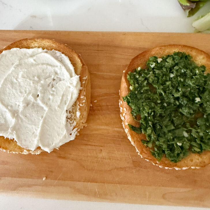 Tahini yogurt sauce and zhug spread onto hamburger buns.