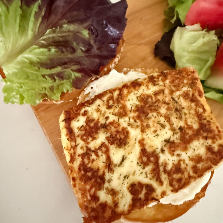 Placing the fried halloumi onto the prepared halloumi burger.