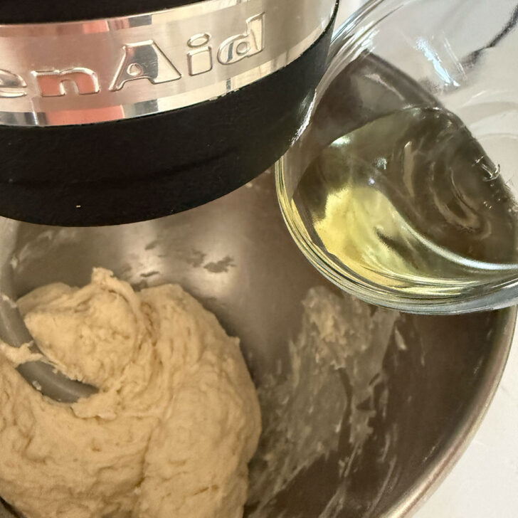 Adding the olive oil to the focaccia dough.