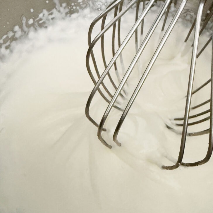 Whipping the cream to soft peaks.