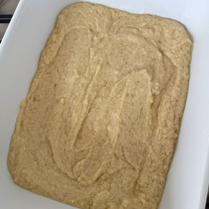 Spoon cake batter spooned into a baking dish.