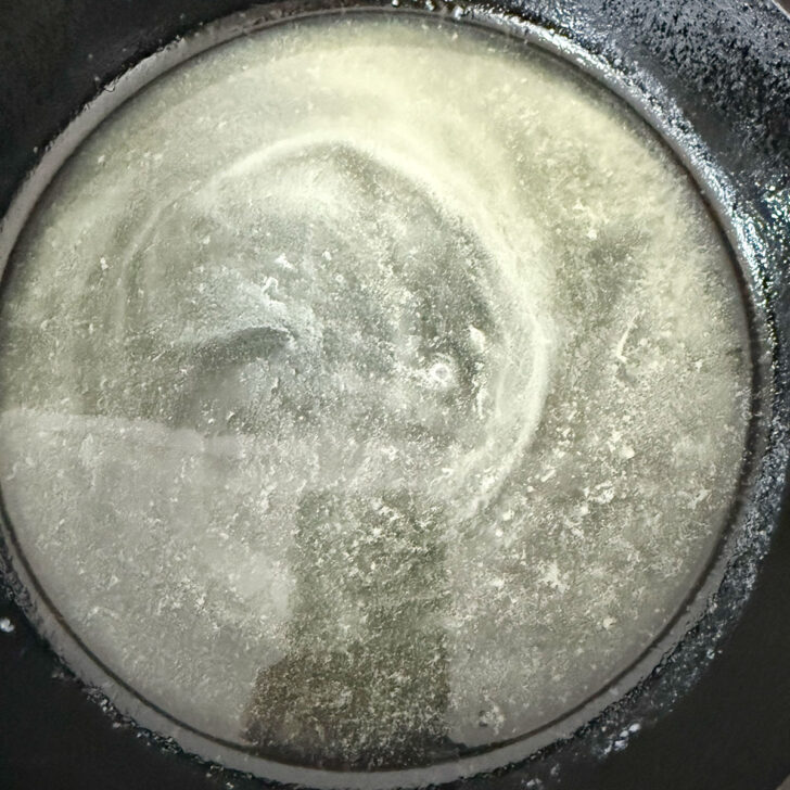 Butter melted in a cast iron skillet.