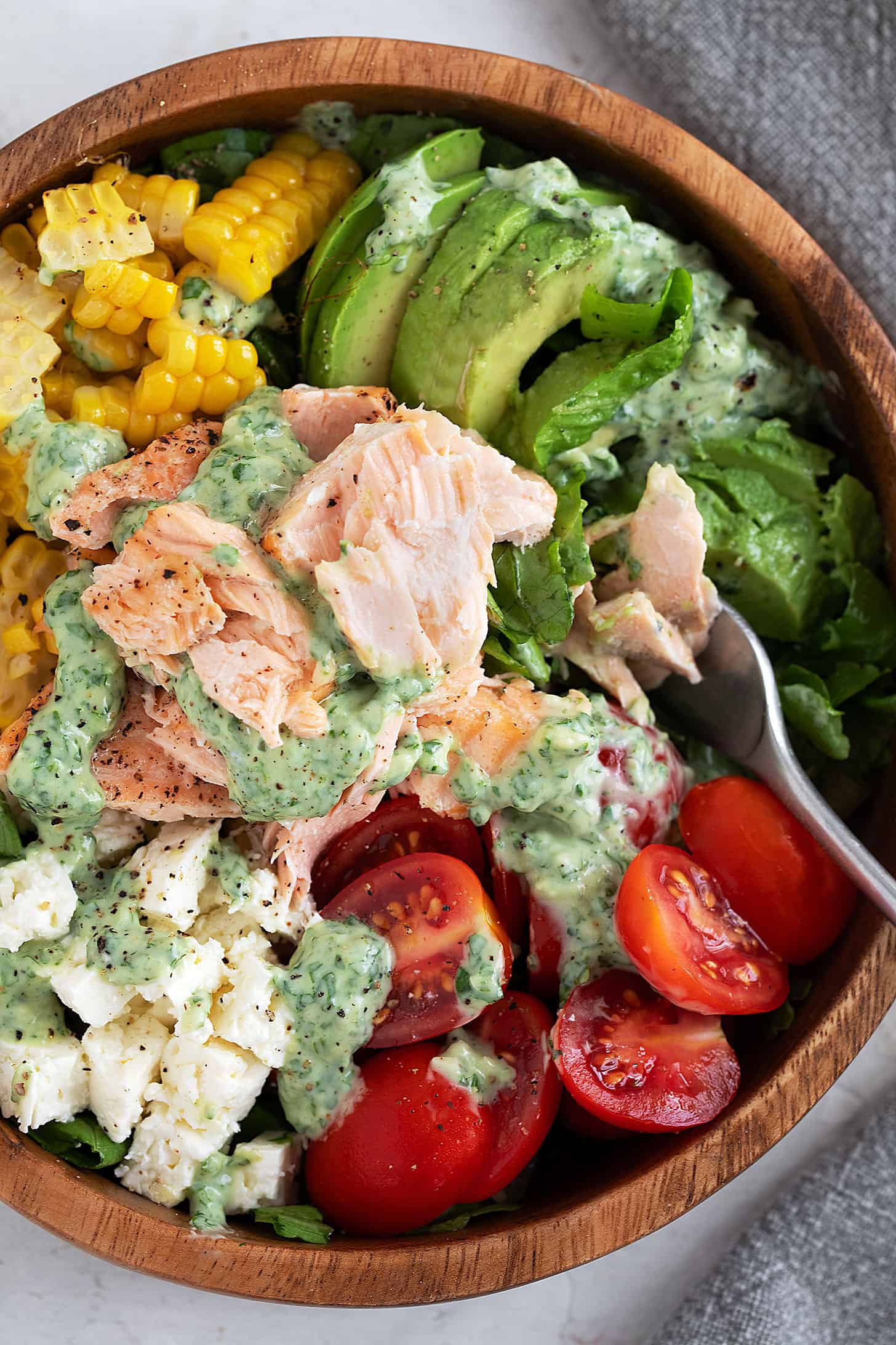 Salmon and corn salad in a salad bowl with cilantro lime dressing.