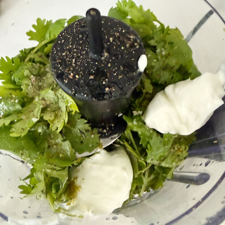 Cilantro lime dressing ingredients added to a food processor.