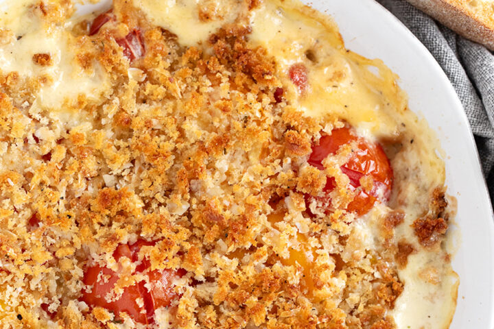 Tomato gratin in the baking dish with toasted bread slices on the side.