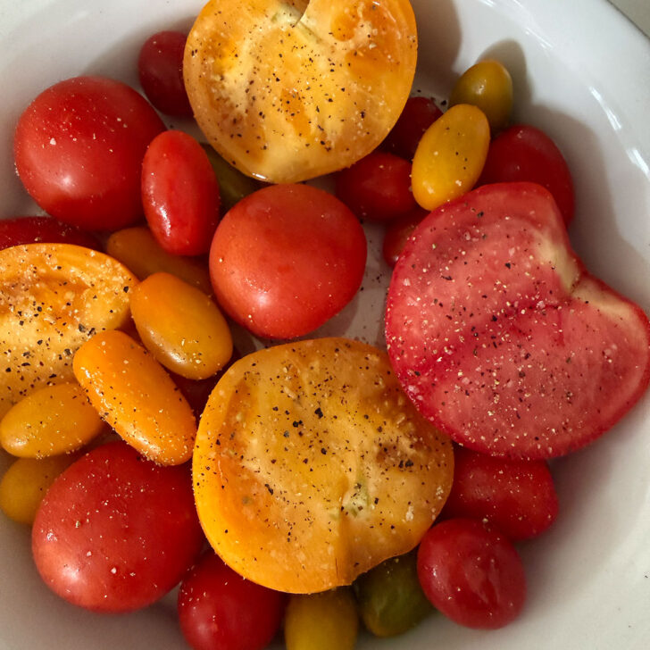 Fresh tomatoes arranged in a shallow baking dish.