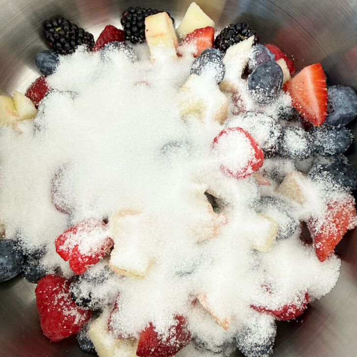 Remaining fresh fruit added to a saucepan with sugar.