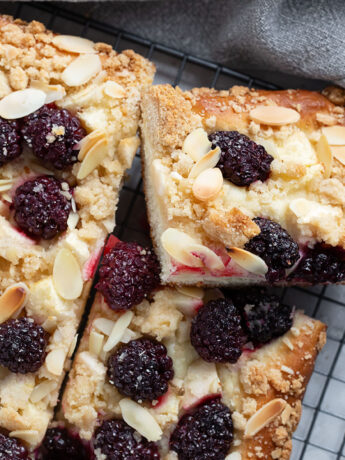 Blackberry apple kuchen sliced on a wire rack.