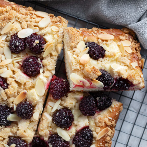 Blackberry apple kuchen sliced on a wire rack.