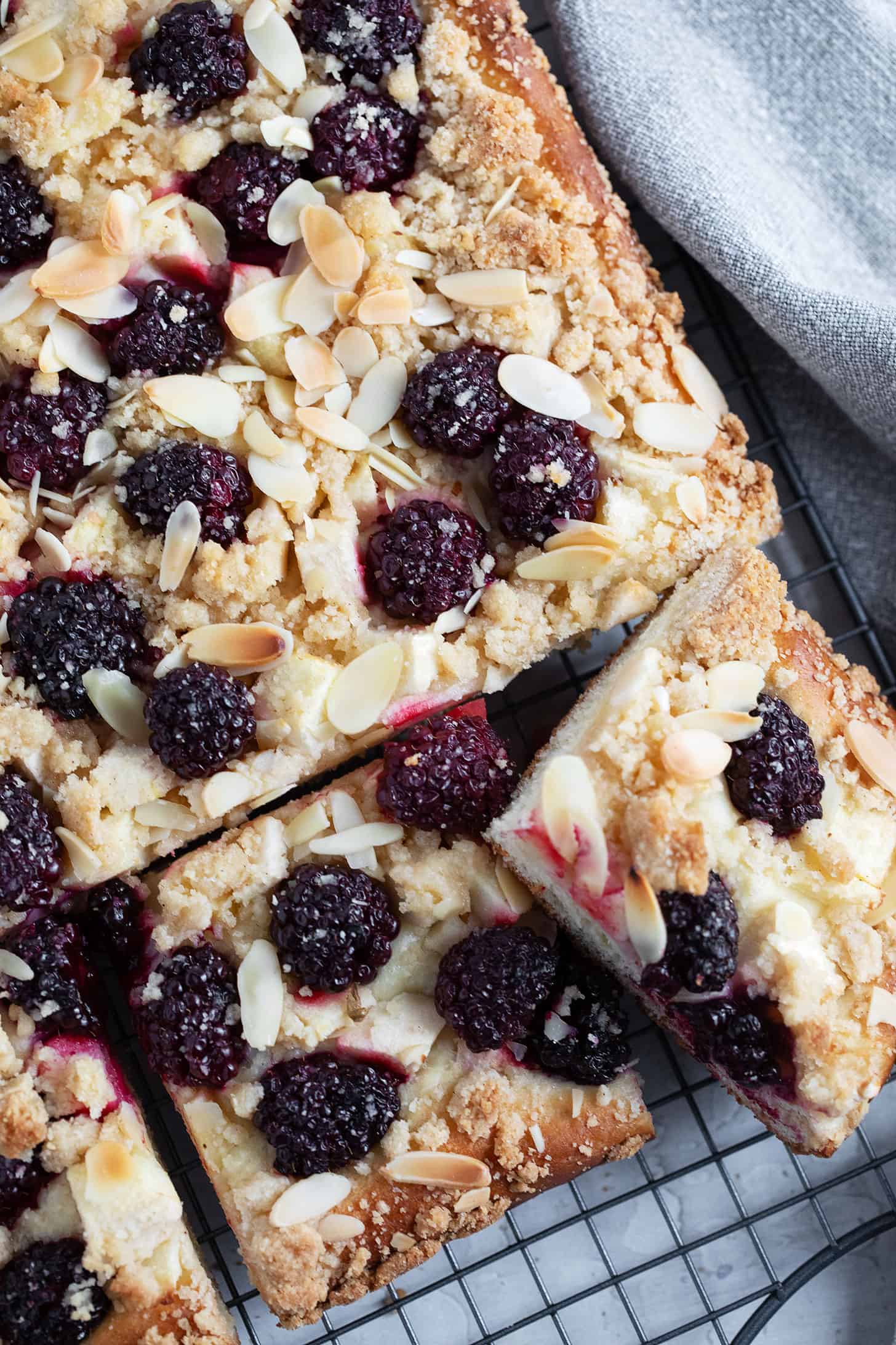 Blackberry apple kuchen sliced on a wire rack.