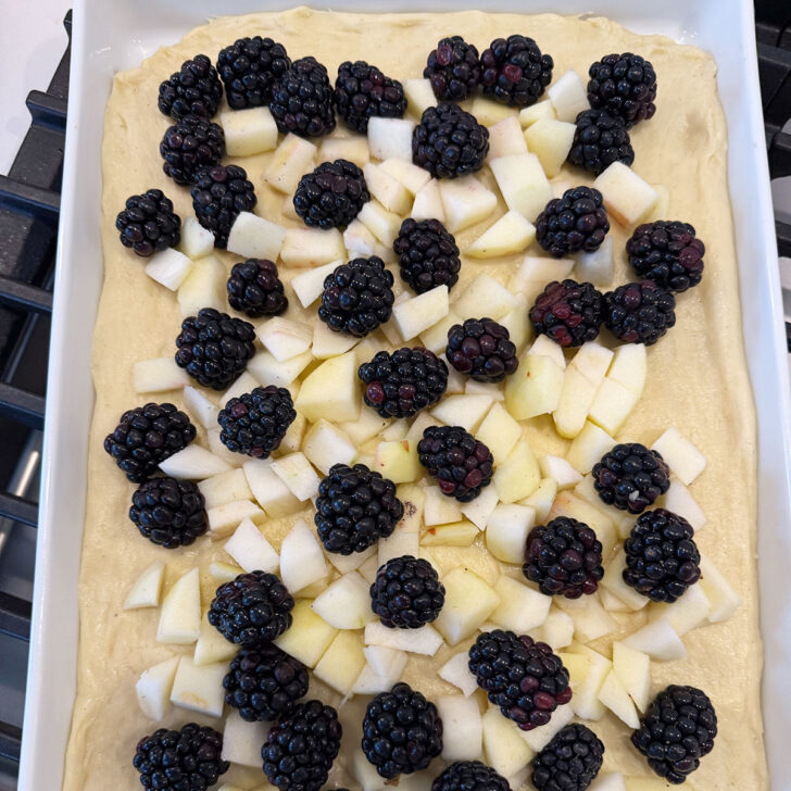 Blackberries and apples scattered over the top of the kuchen dough.