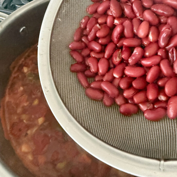 Adding the kidney beans to the minestrone.
