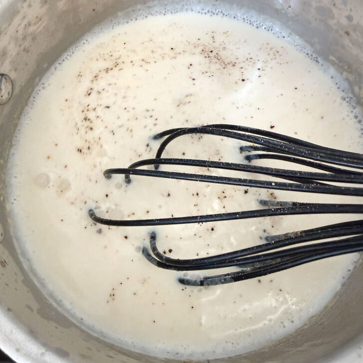 Finished cream sauce in a saucepan.