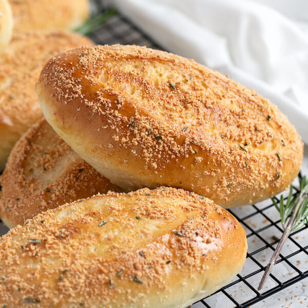 Rosemary Parmesan sandwich buns on a cooling rack.
