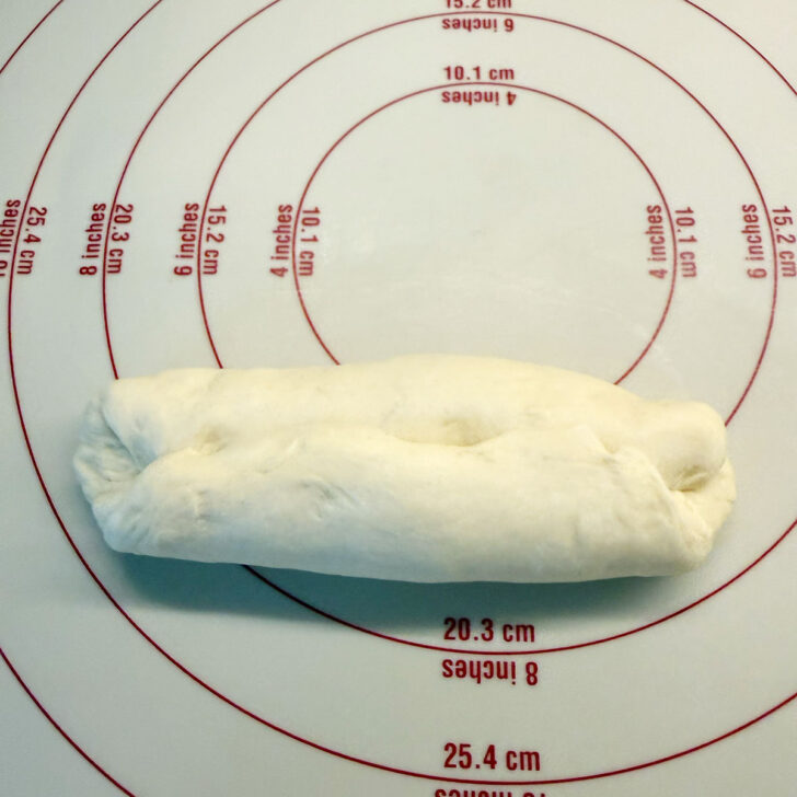Folding the bottom of the oval to the centre.