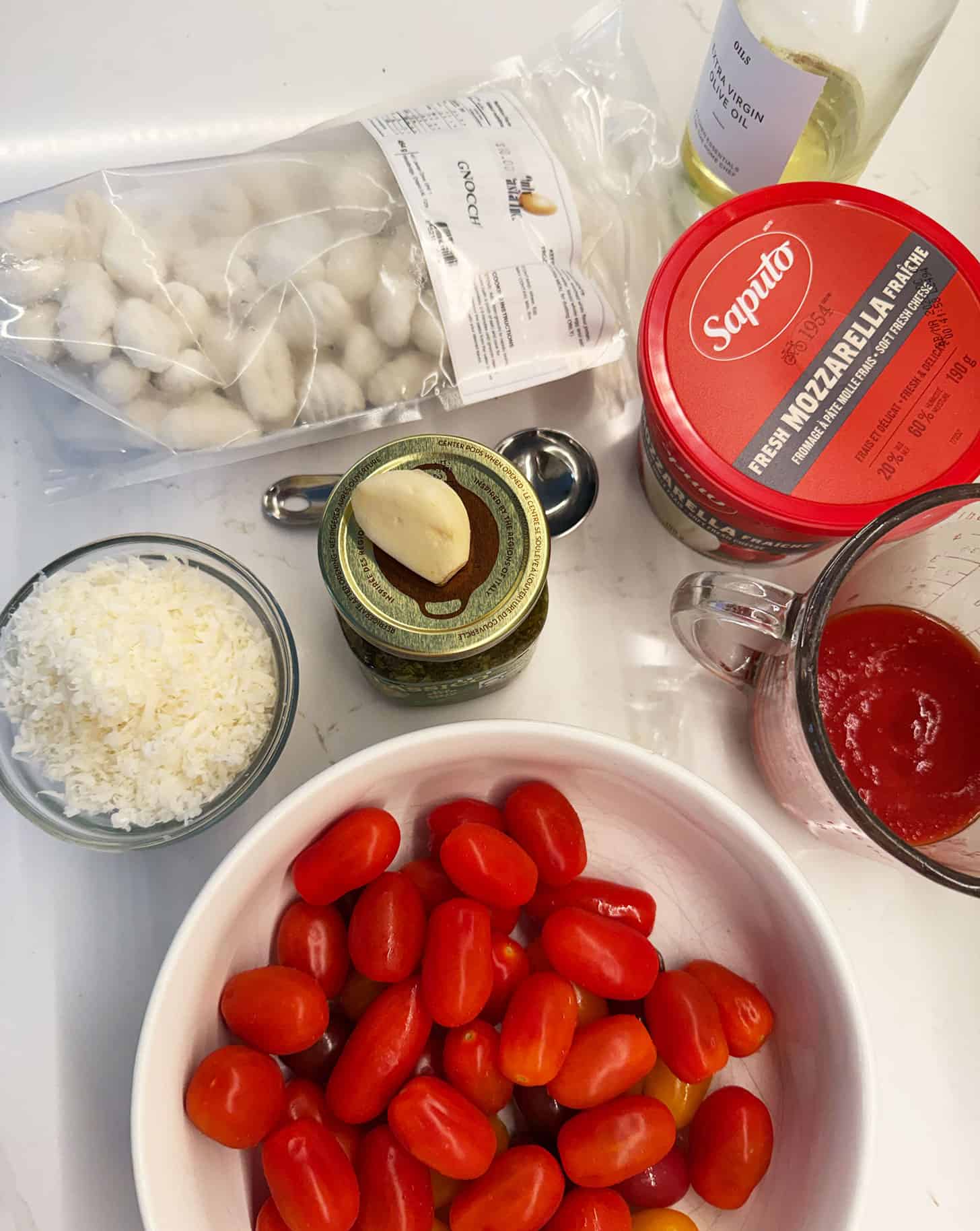 Ingredients assembled for tomato and pesto baked gnocchi.