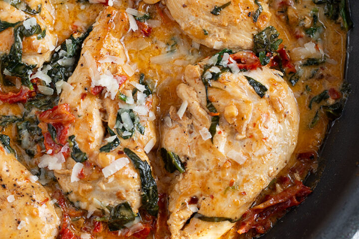 Creamy sun-dried tomato chicken in a skillet.