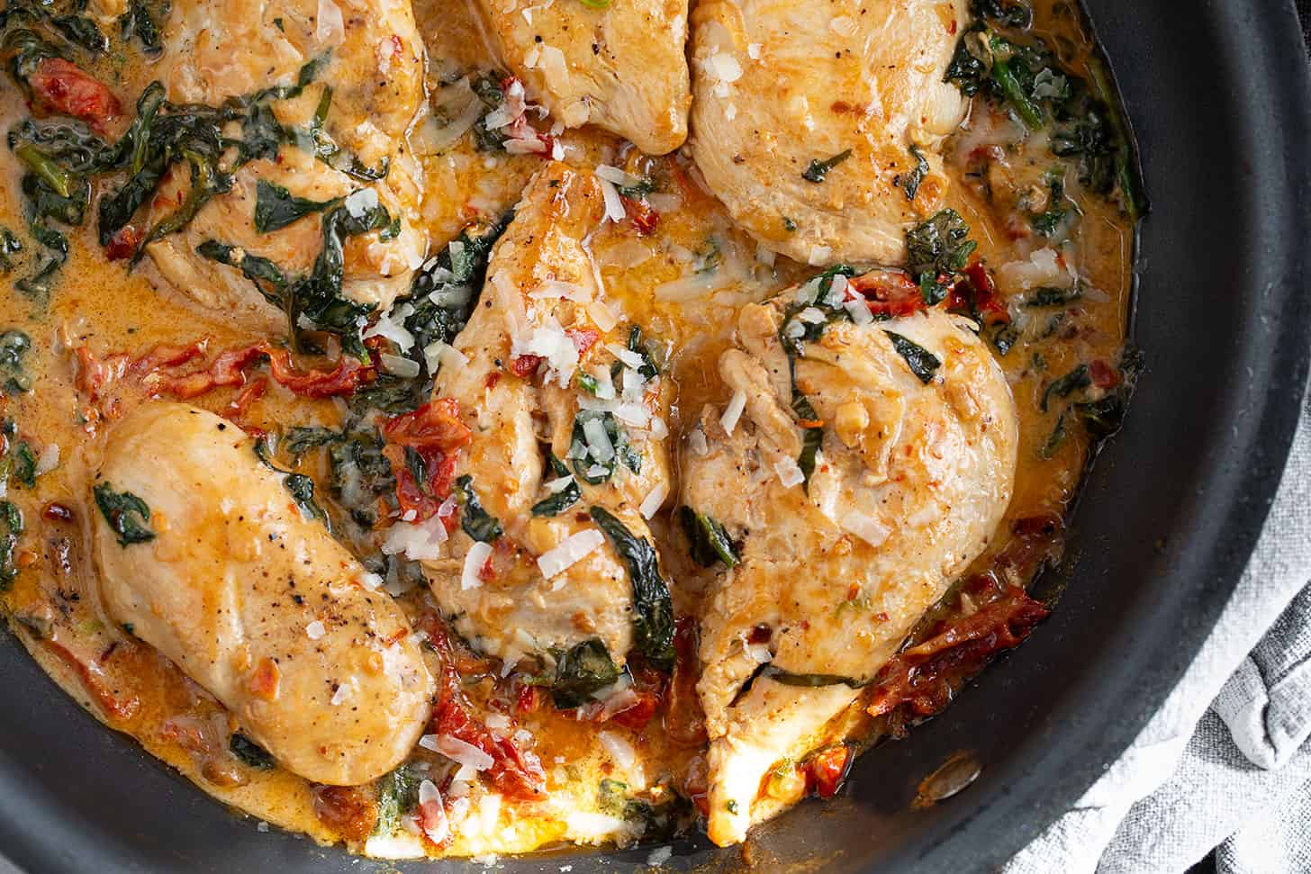 Creamy sun-dried tomato chicken in a skillet.