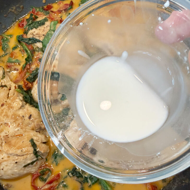 Thickening the sauce with a cornstarch and water mixture.