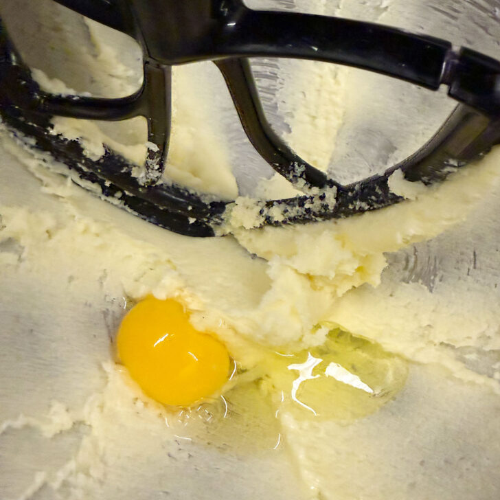 Adding the eggs to the cake batter.