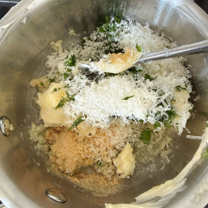 Butter, herbs and Parmesan added to the saucepan with the oil and garlic.