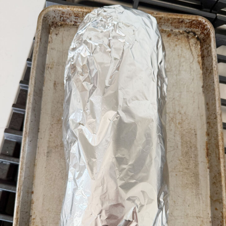 Herb and garlic bread loaf wrapped in foil before placing in the oven.