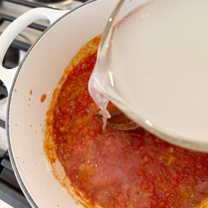 Adding broth to the soup pot.