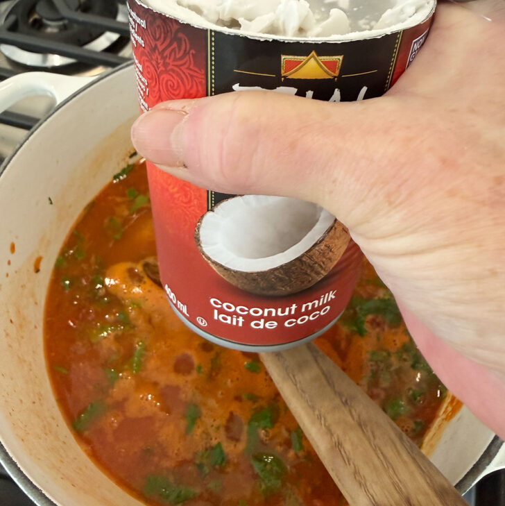 Adding coconut milk to the lentil soup.