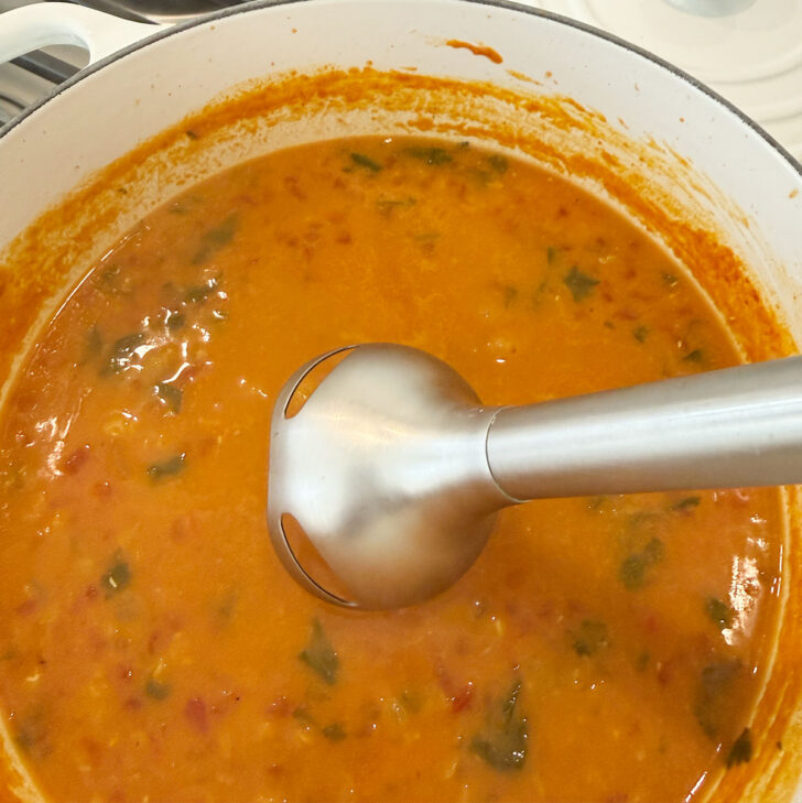 Using an immersion blender to finish the tomato coconut curry lentil soup.