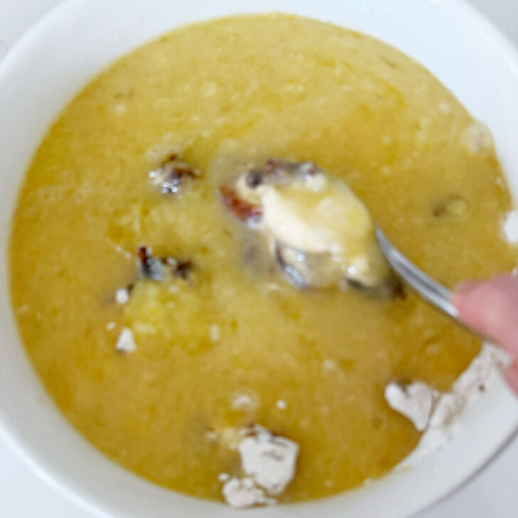 Combining the wet and dry muffin ingredients in a bowl.